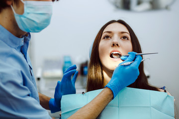 Fototapeta premium Inspection of the teeth of the girl with the help of a mirror