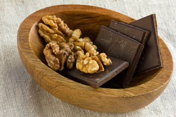 шоколад и орехи на деревянной тарелке