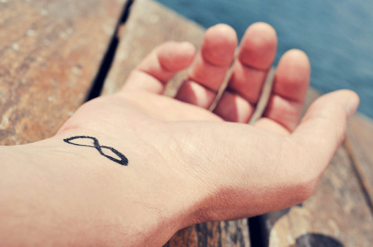 young man with an infinity symbol tattooed in his wrist