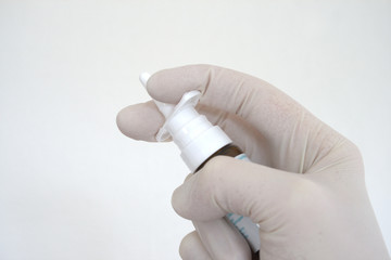 Nasal spray dispenser held by a human hand