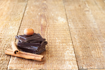 Stack of chocolate slices with nut and cinnamon on a wooden tabl