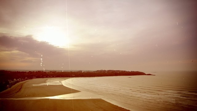 Time-lapse of a bay in evening. Old movie, sepia tones.