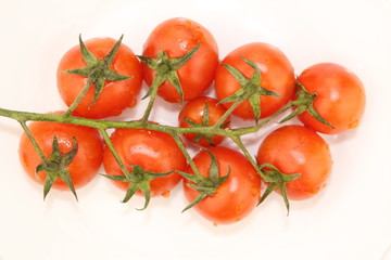 Isolated cluster of fresh ripe red cherry tomatoes