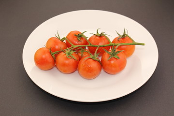 Isolated cluster of fresh ripe red cherry tomatoes