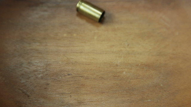 Single 9 mm bullet casing dropped onto wood