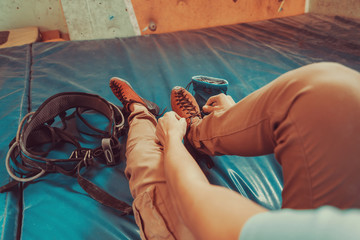 Woman putting on climbing shoes indoor