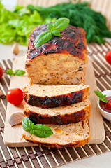 Homemade ground meatloaf with ketchup and basil