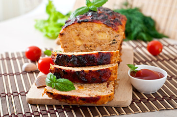 Homemade ground meatloaf with ketchup and basil