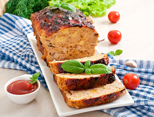 Homemade ground meatloaf with ketchup and basil