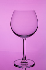 glass with wine on pink background