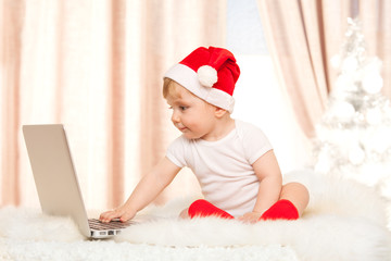 Cute santa baby with laptop