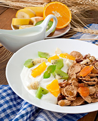 Healthy dessert with muesli and fruit in a white plate on the ta