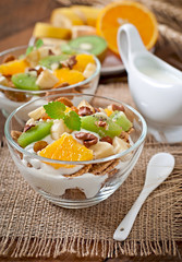 Healthy dessert with muesli and fruit in a glass bowl on the tab