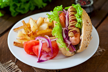 Hot Dogs with French fries on white plate, close-up