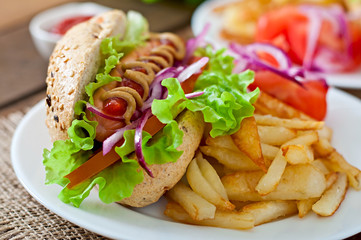 Hot Dogs with French fries on white plate, close-up