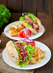 Hot Dogs with French fries on white plate, close-up