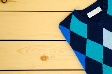 Fototapeta na wymiar Blue sweater on wooden background