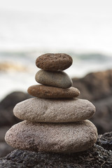Fototapeta na wymiar Stones pyramid on sand symbolizing zen, harmony, balance.