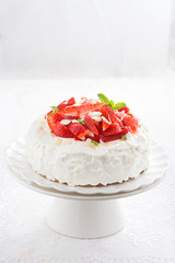 cake with whipped cream and strawberries on a stand, vertical