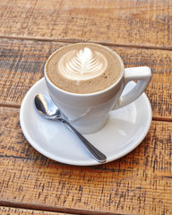 delicious art capuccino cup on wooden background