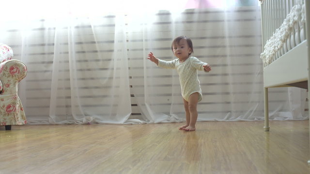one year a small asian baby taking its first steps,dolly shot