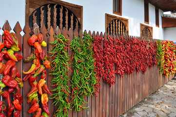 dry peppers hanging at a wooden stockade