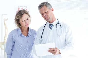 Doctor showing his notes to his patient