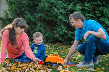 Young family walking in autumn garden