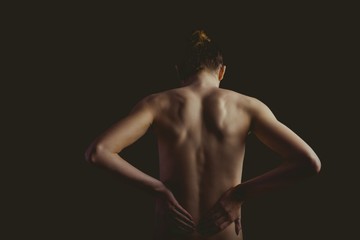 Nude woman with a back injury