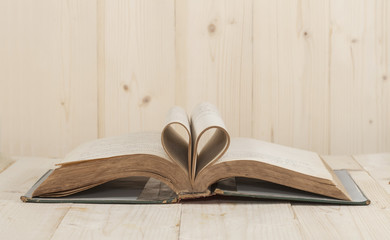 open old book rolled in heart shape