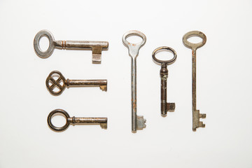 Six old keys to the safe on a white background