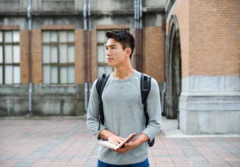 Portrait of college student holding book at college