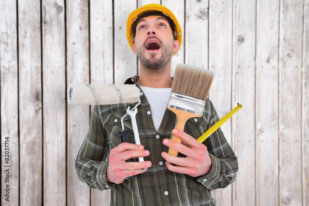 Poster Composite image of screaming manual worker holding various tools