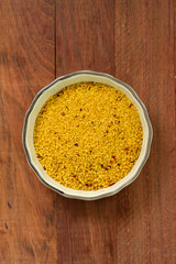 couscous in dish on brown background