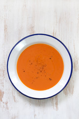 tomato soup in white plate on white wooden background