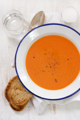 tomato soup in white plate with spoon and toast