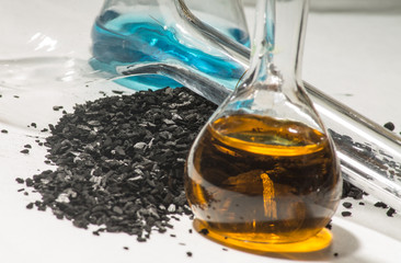 древесный уголь рассыпанный на столе и  колбы с реактивами