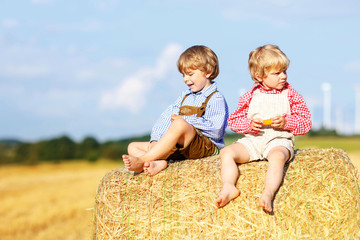 Two little friends and friends sitting on hay stack