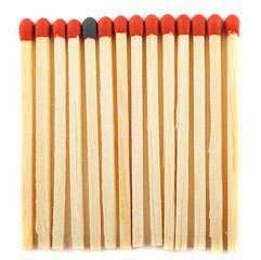 Close up of lined matches, one with a different color