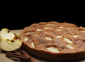 Apple sponge cake on the wooden board. Black background