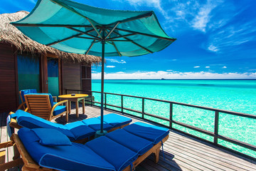 Overwater villa balcony overlooking green tropical lagoon