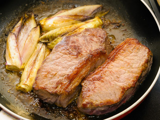 Two tasty pieces of beef tenderloin with endives cooked in a pan