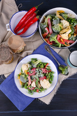 Frozen vegetables on plate on napkin, on wooden table