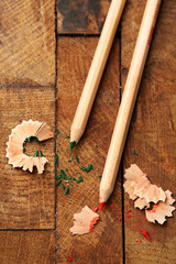 Wooden colorful pencils with sharpening shavings on wooden table