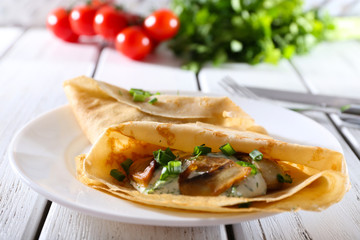 Pancakes with creamy mushrooms and greens in plate