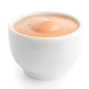 Small white ceramic dish of pink dressing. Isolated.
