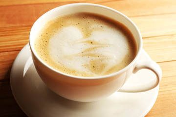 Cup of coffee latte art on wooden table, closeup