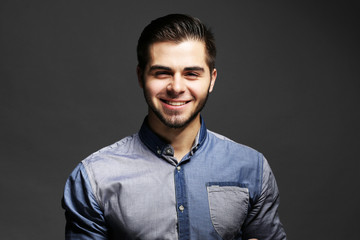 Portrait of young man in blue shirt on gray background