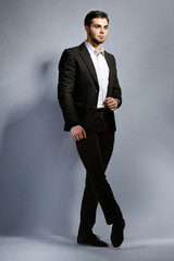 Elegant man in suit on gray background