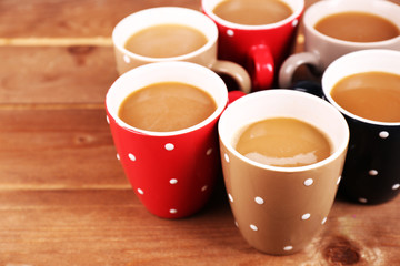 Cups of cappuccino on wooden table, closeup